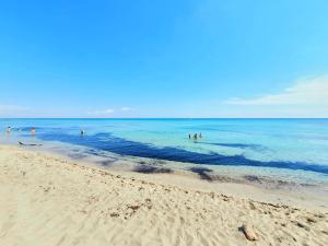 a group of people in the water at the beach at Villa Sette Nani in Torre Lapillo