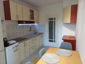 a kitchen with a table and chairs and a kitchen with white cabinets at Corso Residence in Bajina Bašta