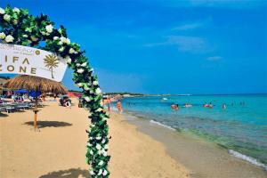 a sign on a beach with people in the water at Villa Sette Nani in Torre Lapillo