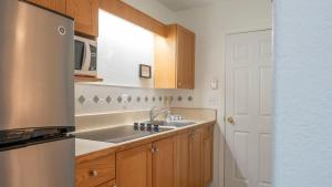 a kitchen with a sink and a refrigerator at The Village Motel in Naramata