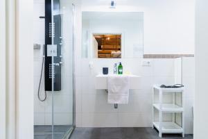 baño blanco con ducha y lavamanos en homebydoni - Küche I Terrasse I 1000 Mbits WiFi I Design Loft nahe RMCC & Staatstheater, en Wiesbaden