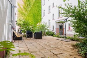 un patio con sillas y plantas en un edificio en homebydoni - Küche I Terrasse I 1000 Mbits WiFi I Design Loft nahe RMCC & Staatstheater, en Wiesbaden