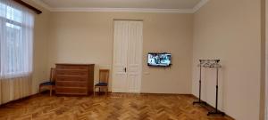 een kamer met een dressoir en een tv aan de muur bij Geo Gogebashvili in Koetaisi