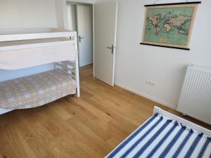 a bedroom with a bunk bed and a wooden floor at Superbe Appartement à 3min à pieds de la gare in Chessy