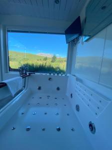a room with a large window with a view at Highland Stays - Ben View Studio Pod & Jacuzzi Bath in Fort William