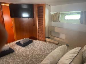 a bedroom with a bed and a tv on a train at Barco El Marques in Barcelona