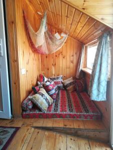 a bed in the corner of a room in a cabin at Three Gracia in Sighnaghi