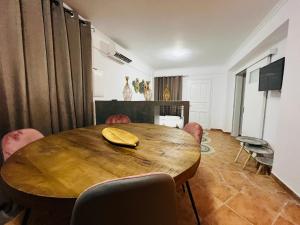 a dining room with a wooden table and chairs at Family Villages Santorini in Vlychada Beach