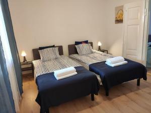 a room with two beds with blue and white sheets at Domek babci Marysi in Krasnobród