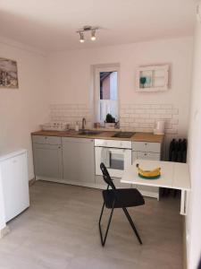 a white kitchen with a banana on a table at Domek babci Marysi in Krasnobród +7 photos