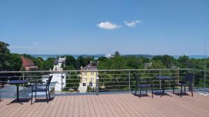 a group of chairs and tables on a balcony at Heléna Apartman Juventus in Balatonföldvár