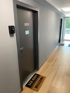 a door with a sign on the floor next to a welcome mat at Heléna Apartman Juventus in Balatonföldvár