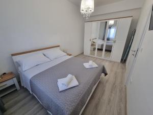 a bedroom with a bed with two white towels on it at Villa Madison in Posedarje