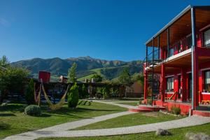 a house with a hammock outside of it with mountains at Apart del Valle in Tafí del Valle