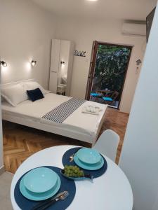 una habitación con una cama y una mesa con platos. en Apartment Cattaro magico, en Kotor
