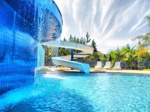 a water slide in the middle of a pool at Hotel Vilage Inn All Inclusive Poços de Caldas By Nacional Inn in Poços de Caldas