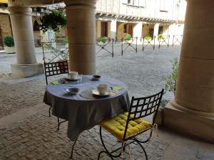 a table with two cups on it in a courtyard at Plume Et Pinceau in Montdragon +9 photos