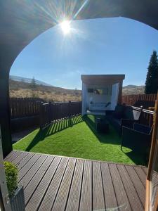 a view of a backyard with a deck and grass at Highland Stays - Ben View Studio Pod & Jacuzzi Bath in Fort William