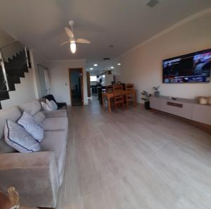 ein Wohnzimmer mit Couch und Flachbildfernseher in der Unterkunft Casa PraiAmar 20 in Prado