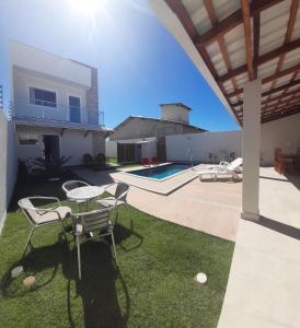 eine Terrasse mit Tisch und Stühlen und einem Pool in der Unterkunft Casa PraiAmar 20 in Prado