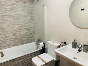 bagno con servizi igienici, lavandino e specchio di Apartamentos Best Ainsa ad Aínsa