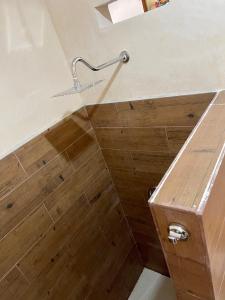 een douche met een houten vloer en een douchekop bij Estudios Rehilete in Holbox Island