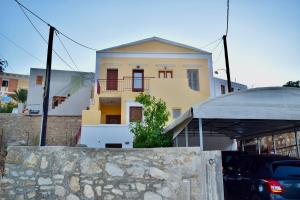 żółto-biały dom z kamienną ścianą w obiekcie ΚΟΥΛΟΥΝΤΡΗ (1) w mieście Simi