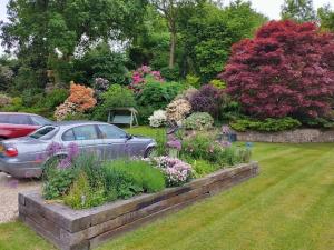 um jardim com um carro estacionado num quintal em The Annexe @Granny’s Apple Lodge em Blakeney