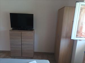 ein Schlafzimmer mit einem Flachbild-TV auf einer Kommode in der Unterkunft Trullo Libellula in Ceglie Messapica