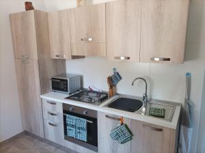 eine kleine Küche mit einem Herd und einer Mikrowelle in der Unterkunft Trullo Libellula in Ceglie Messapica