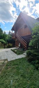 a large house with a gambrel roof with a patio at Święty spokój na pięterku in Stańkowa