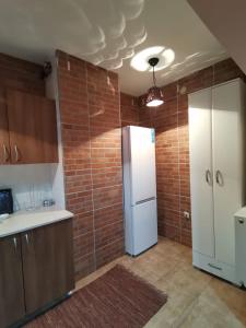 una cucina con frigorifero e muro di mattoni di Apartmani Vojinović a Sjenica