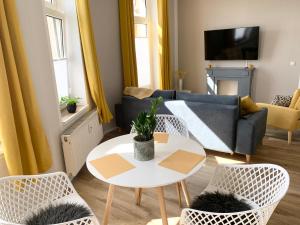 a living room with a couch and a table and chairs at Lovely City-Apartment*Tiefgarage,Zentrum,BTU* in Cottbus