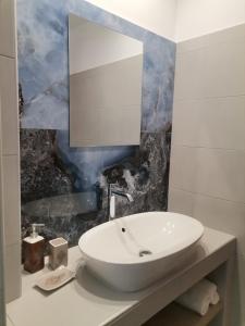a bathroom with a white sink and a mirror at Sea Salt Village House in Samos