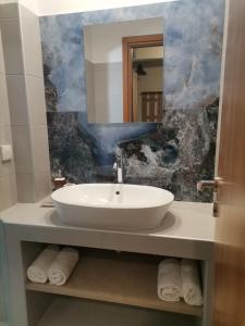bagno con lavandino bianco e specchio di Sea Salt Village House a Samos