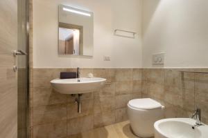 bagno con lavandino, servizi igienici e specchio di Rooms Best Vacation Ever a Cagliari