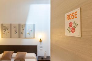 una camera da letto con un letto e due dipinti alle pareti di Rooms Best Vacation Ever a Cagliari