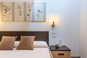 una camera con letto e tavolo con lampada di Rooms Best Vacation Ever a Cagliari