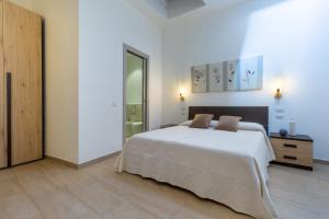 una camera bianca con letto e specchio di Rooms Best Vacation Ever a Cagliari