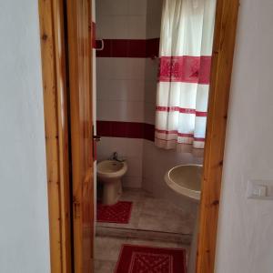 un piccolo bagno con servizi igienici e lavandino di Le Farfalle Appartamento in villa trifamiliare a Porto Istana