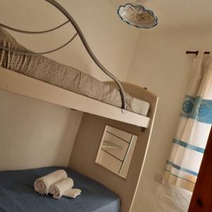 um quarto com 2 beliches e um candeeiro em Le Farfalle Appartamento in villa trifamiliare em Porto Istana