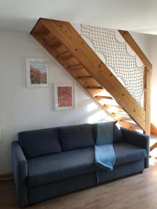 un sofá azul en una sala de estar con una escalera en Spa House Lotus in Terme Čatež en Čatež ob Savi