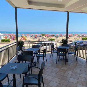 マロッタにあるGFH - Hotel Spiaggia D'Oroのビーチの景色を望むパティオ(テーブル、椅子付)
