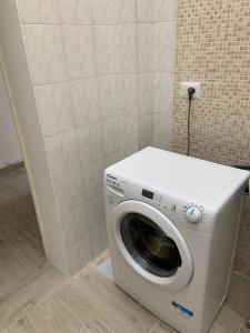 uma máquina de lavar roupa na casa de banho com uma parede em Elena Casa Vacanze 1 em San Donato di Lecce