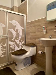 La salle de bains est pourvue de toilettes et d'un lavabo. dans l'établissement Departamento familiar & empresarial, à Machala