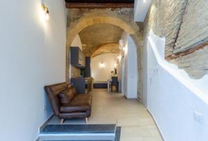 a hallway with a leather chair in a room with arches at Casa Vacanza Home MAF in Cagliari