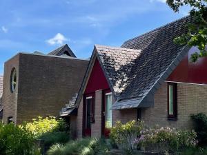 RijsにあるVilla Scorpioの黒屋根の赤い家