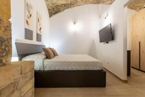 a bedroom with a bed and a flat screen tv at Casa Vacanza Home MAF in Cagliari