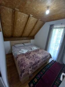 uma pequena cama num pequeno quarto com uma janela em Apartman Stević em Pluzine