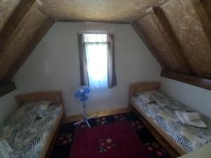 um quarto no sótão com 2 camas e uma janela em Apartman Stević em Pluzine
